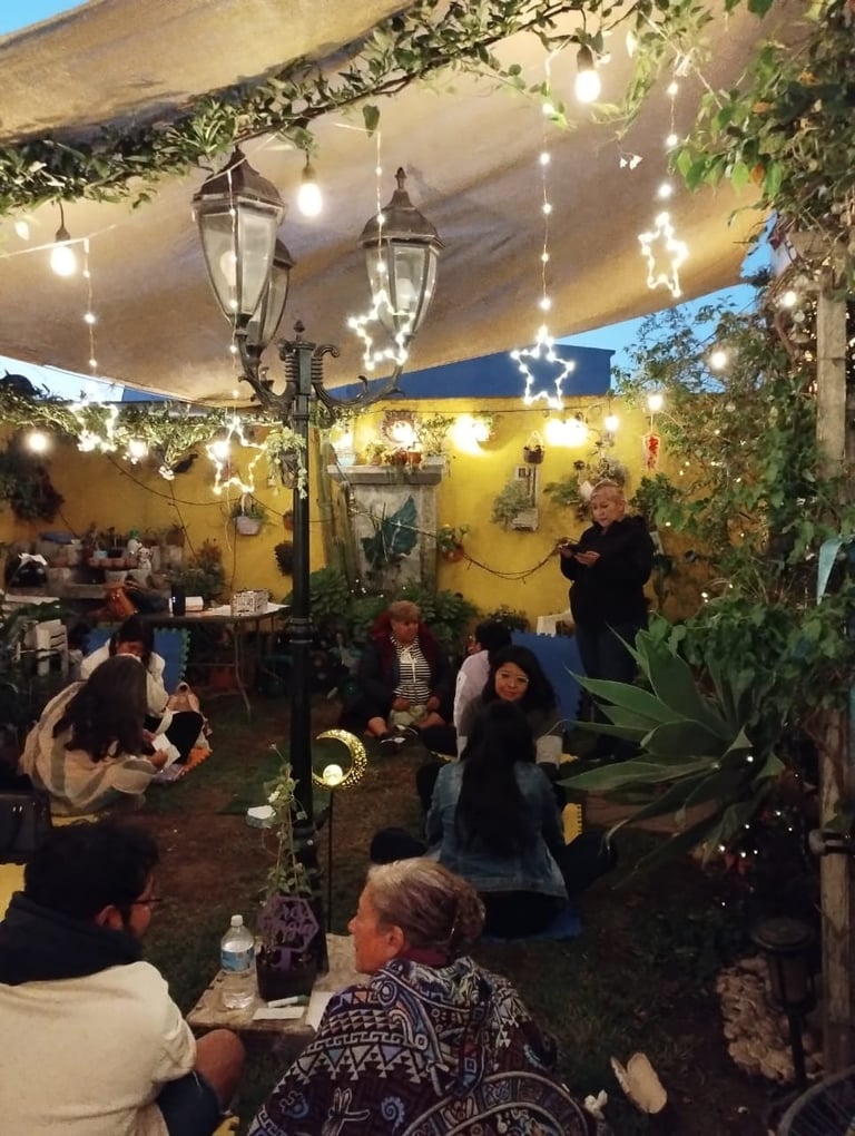 Outdoor patio gathering with string lights, lanterns, yellow walls, and ivy-covered canopy with guests seated at tables